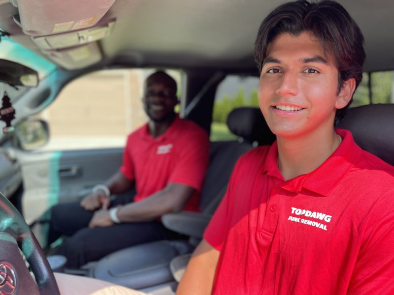 TopDawg Junk Removal crew smiling in truck