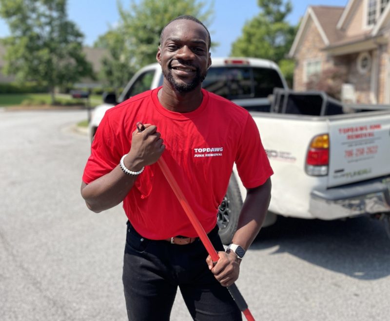 Junk Removal Pro Smiling in front of a truck