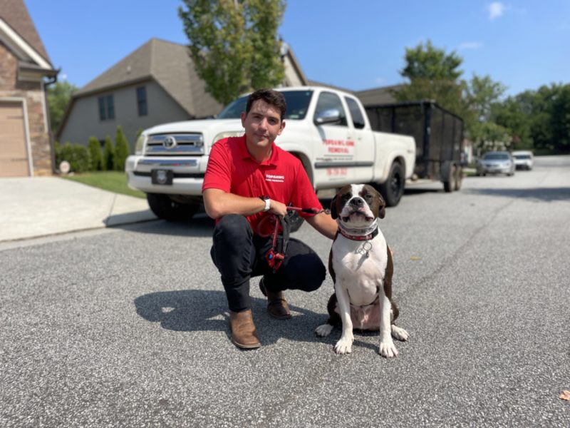 topdawg junk removal pro with dog in front of junk removal truck