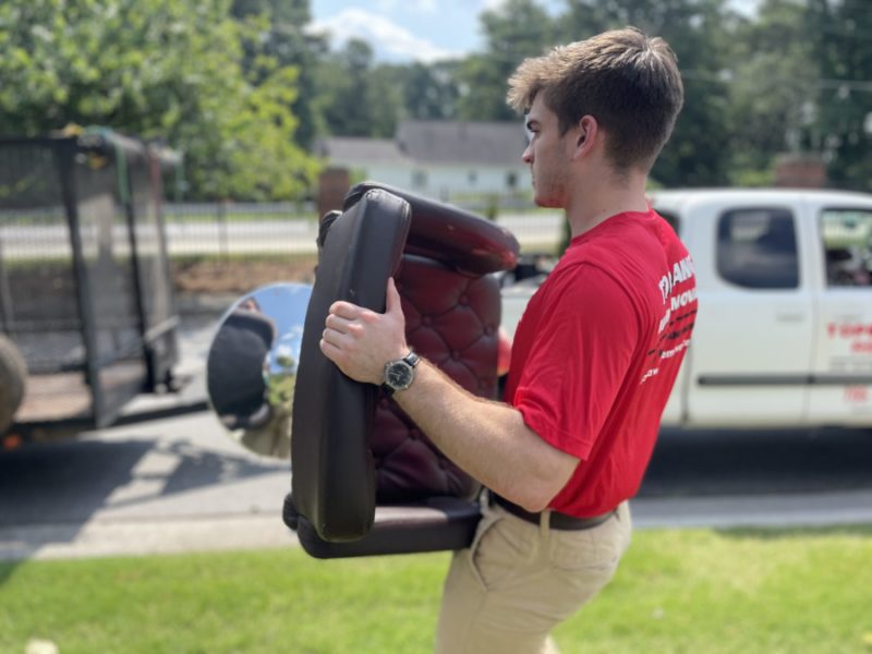 topdawg junk removal pro carrying a chair