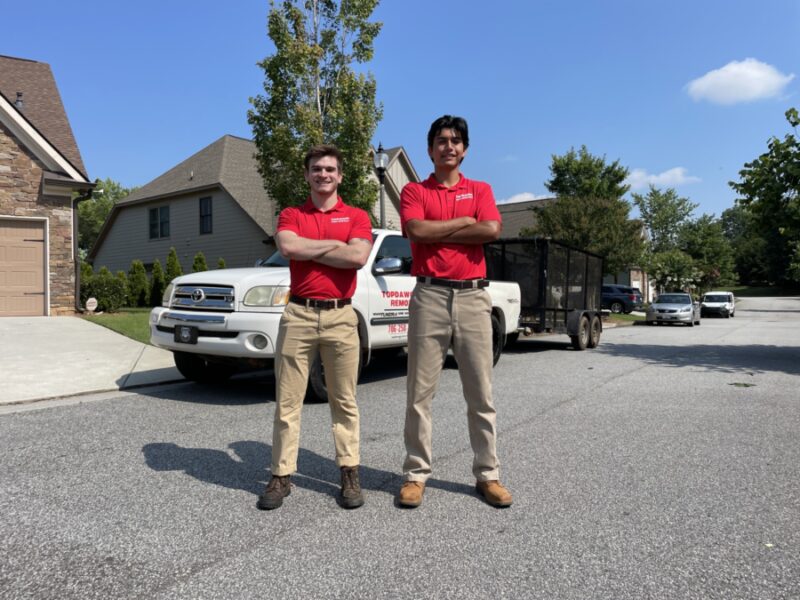 junk removal pros standing in front of topdawg junk removal truck