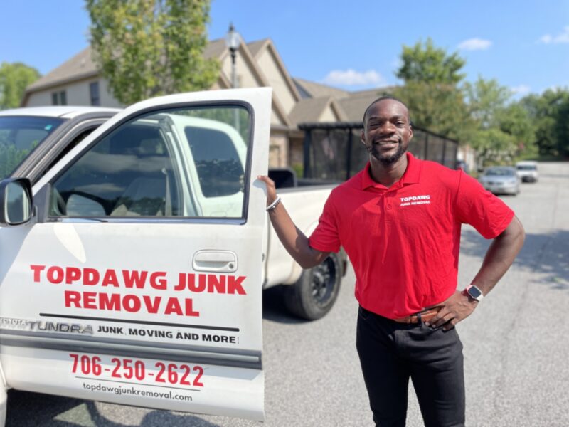topdawg junk removal pro smiling next to truck