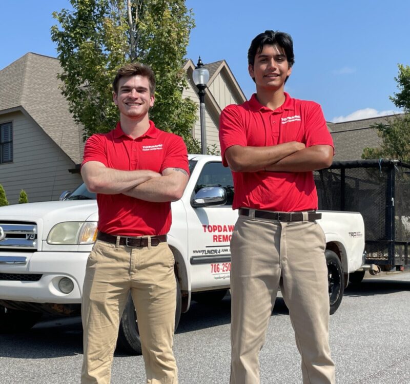 TopDawg Junk Removal professionals smiling near their company truck during curbside junk pickup services