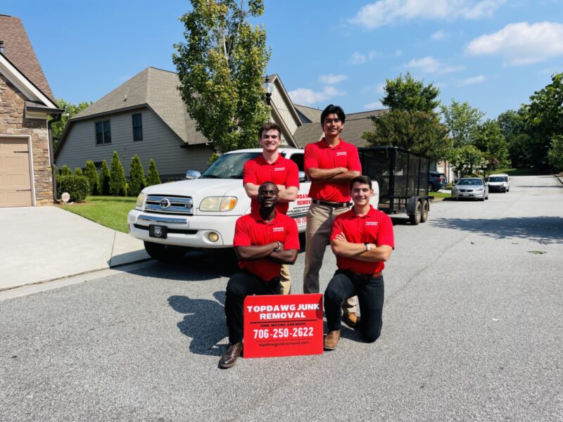 A TopDawg Junk Removal crew posing with a yard sign