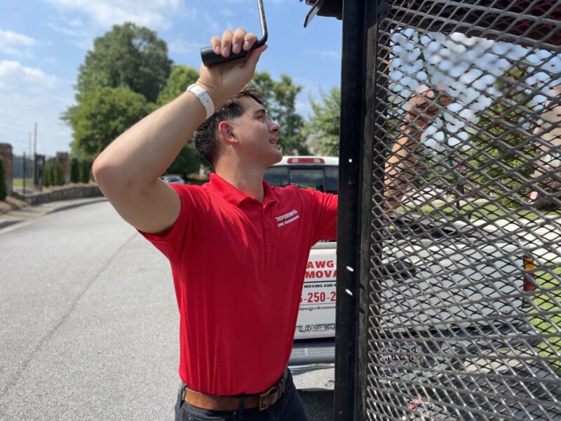 A TopDawg Junk Removal pro closing up a junk trailer