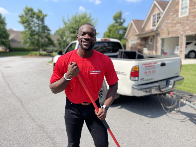 A TopDawg Junk Removal pro posing with a demo tool